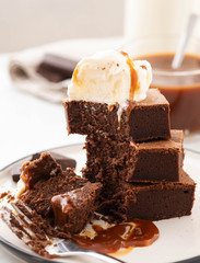 Chocolate brownies with salted caramel, vanilla ice cream. Copy space.