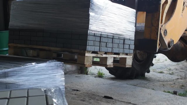 Loader machine loads finished interlocking concrete pavers