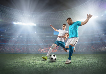 Obraz na płótnie Canvas Soccer player on a football field in dynamic action at summer da