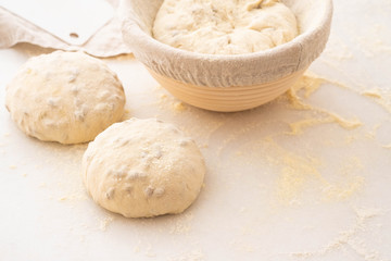 Balls of dough covered with wheat flour ready for baking. Copy space.