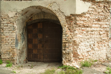 Fototapeta na wymiar Ancient wooden door in old wall