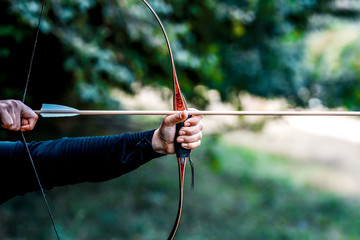 Archer holds his bow aiming at a target