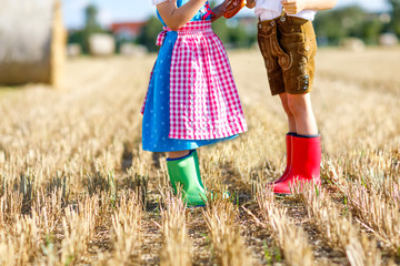 Two kids in traditional Bavarian costumes and red and green rubb