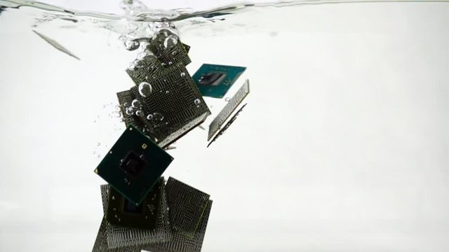 Computer microchips fall into the water, slow motion