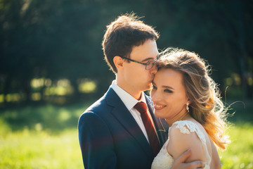 bride and groom embracing on nature background