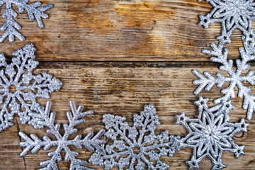 Silvery snowflakes on a wooden background.