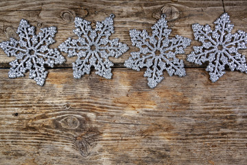 Silvery snowflakes on a wooden background.