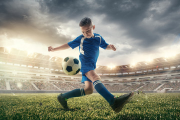 Fototapeta na wymiar Young boy with soccer ball doing flying kick at stadium. football soccer players in motion on green grass background. Fit jumping boy in action, jump, movement at game. Collage
