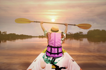 Tourist is enjoy canoe in the river while sunset.