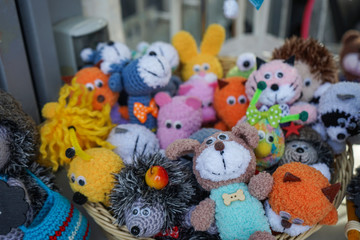 Small knitted toys on the counter of a souvenir shop.