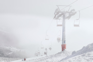 Obraz premium Ski lift chairs on bright winter day
