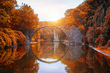 Rakotzbrücke (Rakotzbrucke, Teufelsbrücke) in Kromlau, Sachsen, Deutschland. Bunter Herbst, Reflexion der Brücke im Wasser bilden einen vollen Kreis
