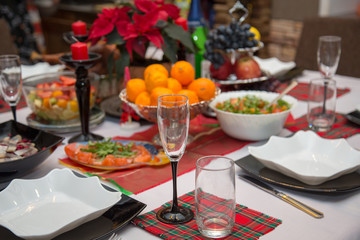 Glass, tangerines and poinsettia
