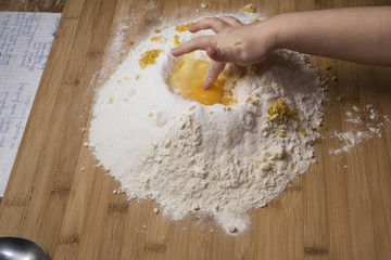 mom and daughter prepare a cake with flour and eggs