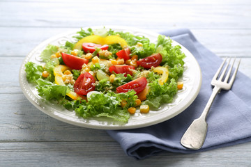 Plate with healthy fresh salad on wooden table