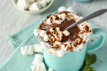 Cup of delicious cocoa with marshmallows on table, closeup