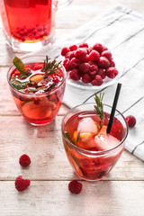 Glasses of fresh raspberry lemonade on wooden table