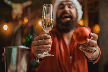 Happy Santa Claus looking at camera. Santa is holding champagne in his hands. Santa Claus wishes Merry Christmas and happy new year. Santa look in camera.
