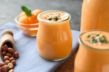 Glass jars of tasty melon smoothie on table