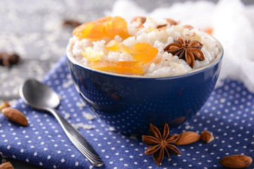 Bowl with delicious rice pudding and dry apricots on napkin