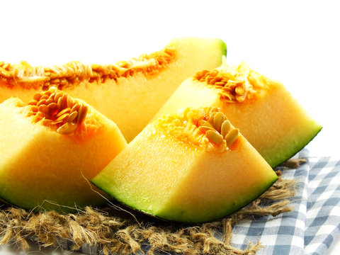 close up of cantaloupe melon slices on white background