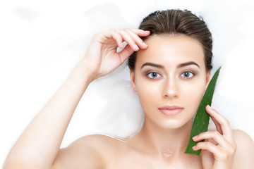 Portrait of young sexy female woman adult with clean pure skin taking spa smiling relaxing in bath with aloe white soap shampoo water. Skin beauty health care concept. Body part bare shoulder