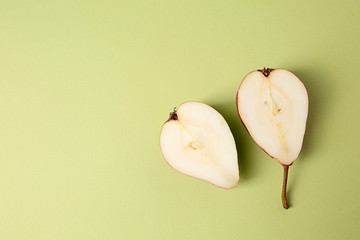 Halves of tasty ripe pear on color background