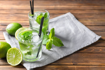 Glasses of fresh mojito on wooden table