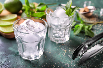 Glass with ice for mojito cocktail on table
