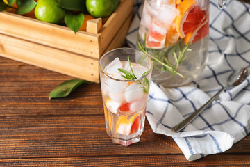 Glass of refreshing grapefruit lemonade on wooden table