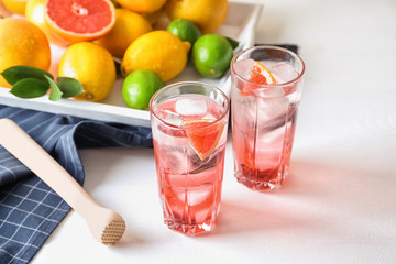 Glasses of refreshing grapefruit lemonade on table