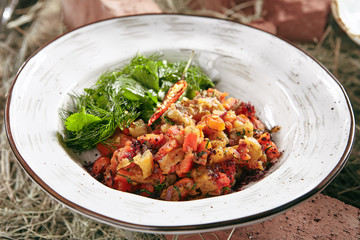 Vegetarian Salad with Baked Vegetables Close Up on Rustic Style Hay Background