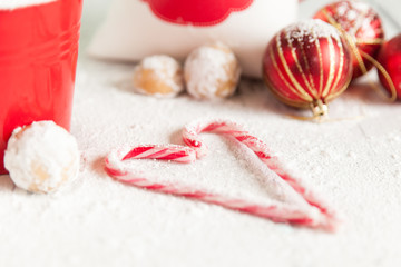 Stripy candy canes in a heart shape. Snowballs cookie balls with powdered sugar
