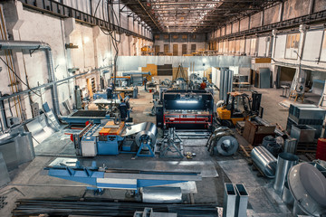 Worksop with machinery tools and equipment, rolls of galvanized steel for production metal pipes...