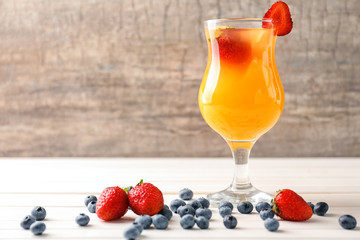 Fresh summer cocktail in glass on white wooden table