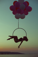 Acrobat girl lying on acrobatic circle.