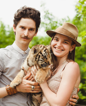 portrait of a young couple with a tiger cub