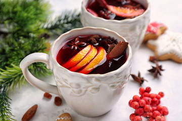 Cup of delicious mulled wine on white table