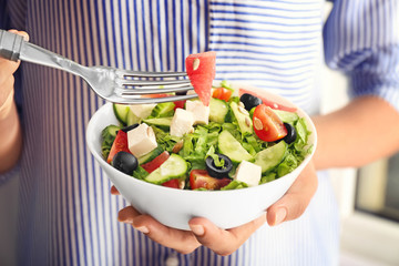 Woman eating tasty salad with watermelon and feta, closeup