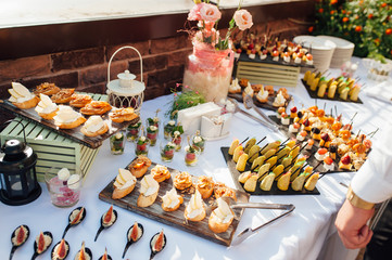 Delicious snacks on wedding reception table in luxury outdoor restaurant