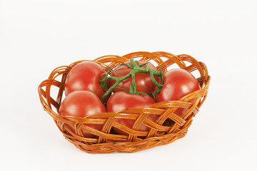 branch of ripe tomatoes in a wicker basket.isolated on white