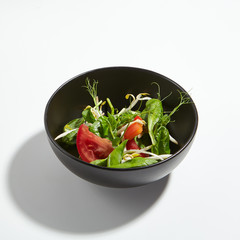 Crunchy Vegetables Green Mix in Round Black Bowl Isolated on White Background