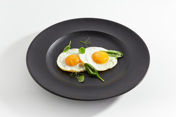 Fried Eggs Decorated with Fresh Spinach Leaves and Young Pea Shoots