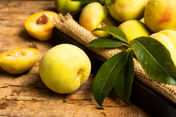 Yellow peaches on rustic wooden table
