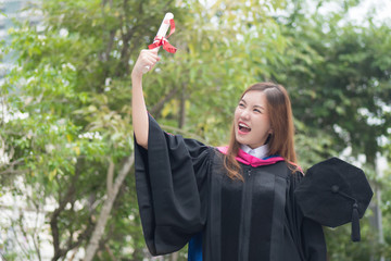 Fototapeta na wymiar happy successful smiling cheerful woman university student graduating; portrait of diploma or college woman student with graduation degree, education success concept; asian 20s young adult woman model