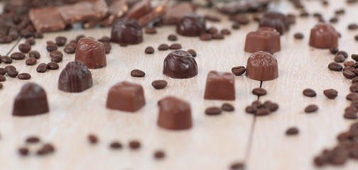 background image of black coffee grain and chocolate candy on wo