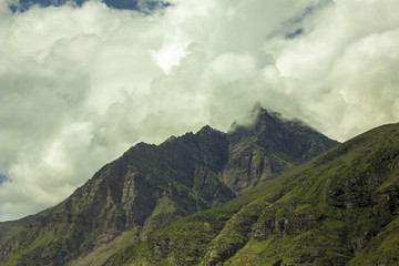 Fototapeta na wymiar green mountains hills and heavy clouds