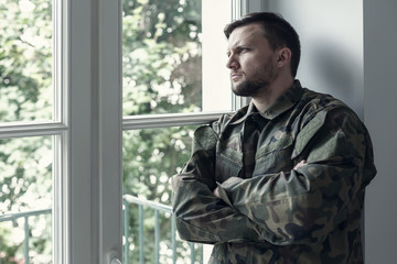 Professional soldier in green moro uniform with war syndrome and violence problem
