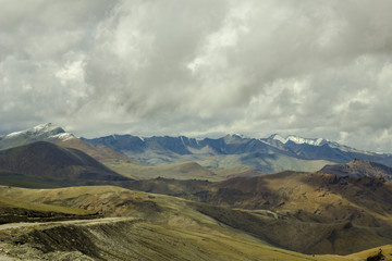 Fototapeta na wymiar High mountain desert valley with snow ridges of mountains
