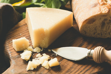 Parmesan cheese and cheese knife on wooden board. Toned image, selective focus © Vladislav Noseek